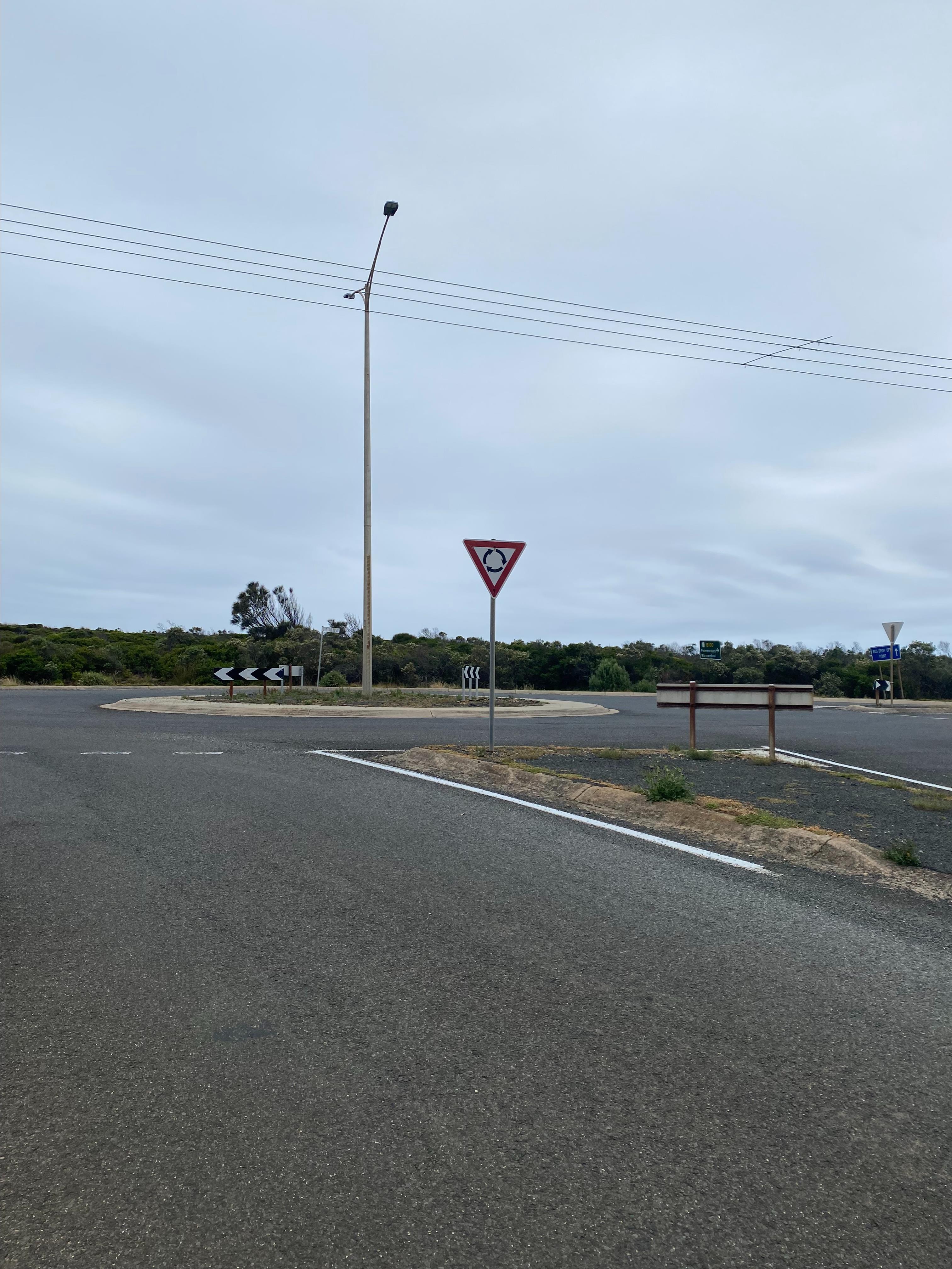 A roundabout on the Great Ocean Road/Morris Street in Port Campbell. There is a street light in the centre of the roundabout.
